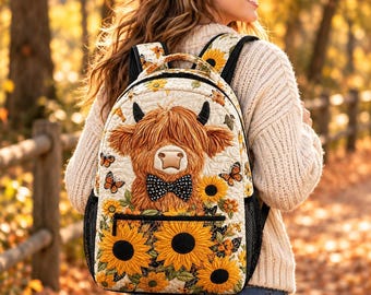 May include: A quilted backpack featuring a central graphic of a brown Highland cow wearing a black and white polka dot bow tie, surrounded by yellow sunflowers and orange butterflies on a cream-colored background with black mesh side pockets.