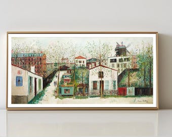 May include: A framed landscape painting depicts a European village scene. The artwork features buildings with red tile roofs, a windmill, and lush green trees. The painting is encased in a gold-colored frame and rests against a white wall.