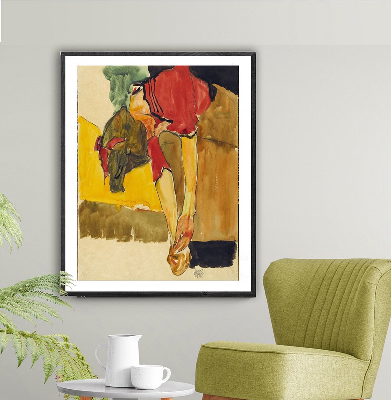 Puede incluir: Una pintura al agua de una persona con una camisa roja, tumbada sobre una superficie amarilla y marr&oacute;n. Las piernas de la persona est&aacute;n extendidas y los brazos doblados por los codos. La pintura est&aacute; enmarcada en negro.