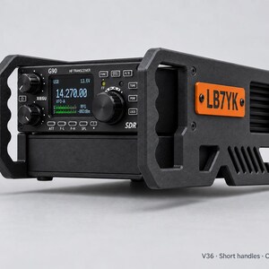 Puede incluir: Un transceptor HF Xiegu G90 negro con una pantalla digital que muestra 14.270.00, encerrado en un marco protector negro con asas integradas. Una placa rectangular naranja con el texto negro LB7YK está montada en el marco lateral.