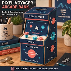Pode incluir: Um mealheiro estilo arcade azul-escuro com gráficos espaciais, incluindo planetas e uma nave espacial pixelizada. A frente exibe o texto PIXEL VOYAGER, NEXT LEVEL FUND e DROP A COIN / DREAM BIG, com três botões circulares no painel.