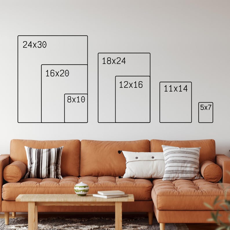 US Print Sizes on Wall behind brown couch.