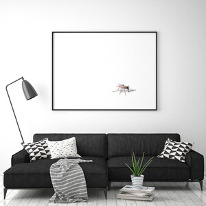 May include: A black sofa with a white and black patterned throw pillow and a green plant in a white pot. A black framed picture with a white background and a mosquito on it hangs on the wall above the sofa.