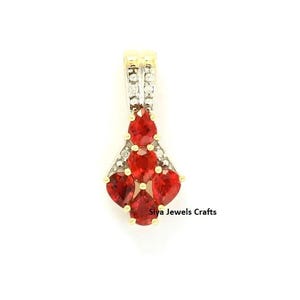 May include: A pendant featuring four pear-shaped red gemstones arranged in a cluster, accented by small clear stones set in a gold-toned metal frame. The text Siya Jewels Crafts is visible at the bottom right of the jewelry piece.