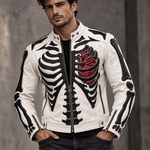 May include: A white leather jacket featuring a black skeleton rib cage design across the front and sleeves, with a prominent red anatomical heart graphic on the left chest, a stand-up collar with snap buttons, and a full-length front zipper closure.