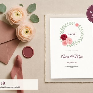 Puede incluir: Una tarjeta de programa de boda con una corona floral de rosas rosas y rojo oscuro, las iniciales A&M, los nombres Anna & Max, la fecha 12. Juni 2027 y detalles de ubicación. Incluye un sobre rosa empolvado, un sello de cera y dos ranúnculos.