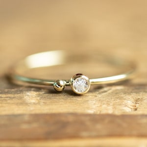 14k solid gold ring with a small Diamond and golden ball