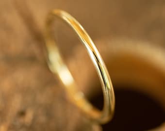 May include: A simple gold band ring, a classic and timeless design.