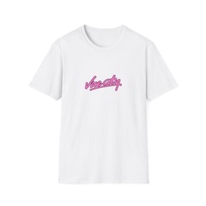 Könnte beinhalten: Ein weißes kurzärmeliges T-Shirt mit dem Schriftzug "Vice City", der in einer stilisierten rosa Schreibschrift mit dünner schwarzer Umrandung mittig auf der Brust aufgedruckt ist. Das Kleidungsstück hat einen Rundhalsausschnitt.