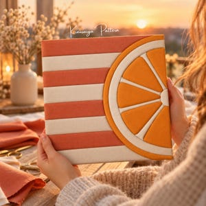 May include: A square Kinusaiga pattern art piece featuring horizontal stripes in alternating shades of coral and cream, with a large, semi-circular orange slice design on the right side rendered in vibrant orange and white fabric segments.
