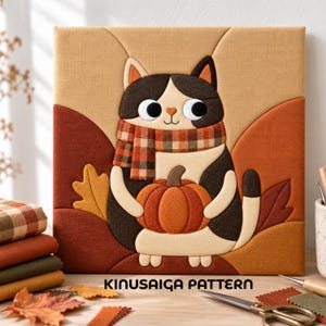 May include: A square fabric wall art piece featuring a Kinusaiga pattern of a black, white, and brown cat wearing a plaid scarf and holding an orange pumpkin. The background displays autumn leaves in shades of brown, orange, and tan.