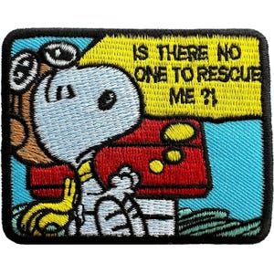 May include: A rectangular embroidered patch featuring a white cartoon dog with black ears and a yellow collar, sitting in front of a red doghouse. The background is light blue, and a yellow speech bubble contains the text IS THERE NO ONE TO RESCUE ME?!
