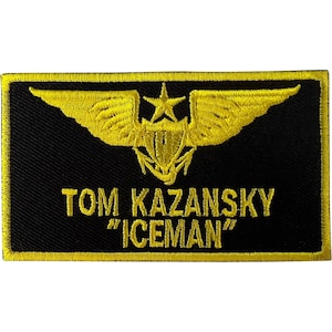 May include: A rectangular black embroidered patch with a yellow border. It features a yellow embroidered emblem of wings and a star above an anchor. The text TOM KAZANSKY "ICEMAN" is embroidered in yellow capital letters below the emblem.