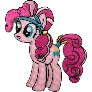 May include: An embroidered iron-on patch featuring a light pink pony character with a curly dark pink mane and tail. The pony has large blue eyes, a light blue headband, and a small yellow and blue balloon symbol on its flank, outlined in black.