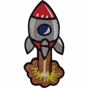 May include: An embroidered patch featuring a rocket ship with a red nose cone, silver body, and a blue circular window. The rocket is depicted launching with a brown cloud of smoke and bright yellow flames emerging from the base, all outlined in black.