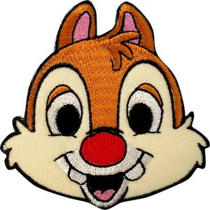 Può includere: Una toppa ricamata raffigurante la testa di uno scoiattolo dei cartoni animati con pelliccia arancione, viso color crema, grandi occhi neri e un naso rosso brillante. Il personaggio ha due denti anteriori prominenti e una bocca sorridente.