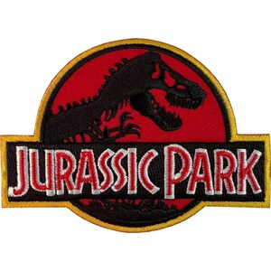 Pode incluir: Um emblema bordado circular apresentando a silhueta preta de um esqueleto de Tyrannosaurus Rex sobre um fundo vermelho. Uma faixa preta horizontal no centro exibe o texto JURASSIC PARK em branco e vermelho com uma borda amarela.