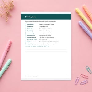 May include: A white worksheet titled Thinking traps with a dark teal header. It lists cognitive distortions like Catastrophizing and Mind reading with checkboxes and definitions. The page includes blank lines for writing and the text The CALMA Workbook.