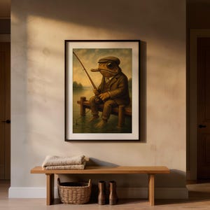 May include: A framed wall art print depicting a toad wearing a brown suit and a flat cap, sitting on a wooden pier while holding a fishing rod. The toad is positioned over a calm body of water with a soft, muted color palette of browns and greens.