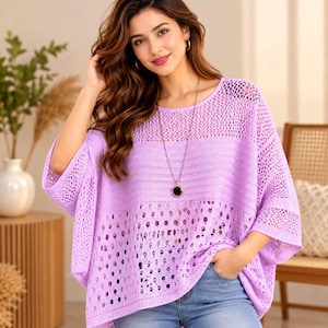 May include: A light purple knit top featuring a loose, oversized fit with wide sleeves and a combination of openwork mesh and solid horizontal knit panels. The garment is paired with blue denim jeans and a long necklace with a round pendant.