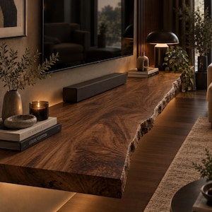 May include: A long, dark brown wooden floating shelf with a natural live edge, mounted beneath a television. The shelf features a prominent wood grain pattern and is illuminated by integrated warm LED lighting along the bottom edge.