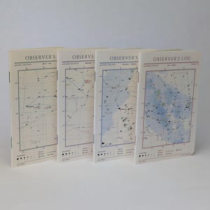 May include: Four softcover notebooks titled Observer's Log, each featuring a unique seasonal star chart on the cover. The notebooks are arranged in a row, displaying distinct color palettes for spring, autumn, winter, and summer editions.