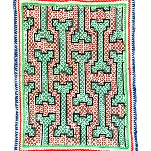 May include: A green, red, and black geometric pattern is embroidered on a white fabric square. The fabric is surrounded by a blue, red, and green border.