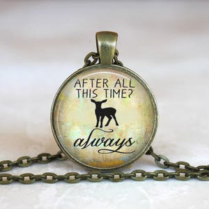 以下が含まれることがあります： 鹿のシルエットと「After all this time? Always」というテキストが描かれた丸いガラス製のペンダントが付いたブロンズネックレスです。