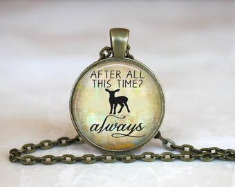 May include: A bronze necklace with a round glass pendant featuring a deer silhouette and the text "After all this time? Always".
