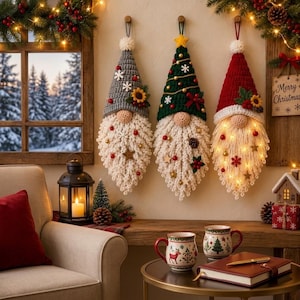 May include: Three hanging crochet gnome decorations with pointed hats in gray, green, and red. Each gnome features a textured white beard adorned with small ornaments, stars, and snowflakes. The red gnome includes integrated warm fairy lights.