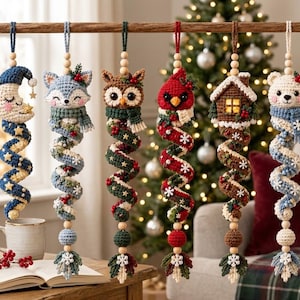 May include: Six hanging crochet ornaments featuring a moon, fox, owl, cardinal, house, and bear. Each figure has a long, spiraling tail decorated with small stars, snowflakes, or berries, and is accented with wooden beads and a hanging loop.