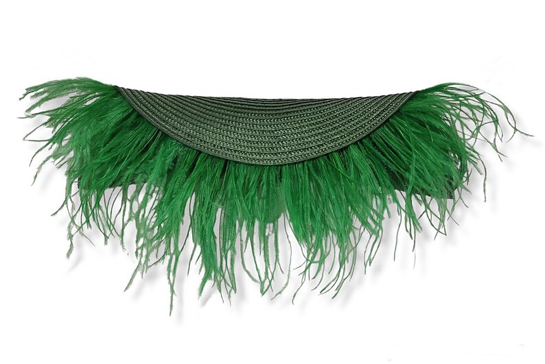 May include: A green straw hat with a wide brim and a feather trim.