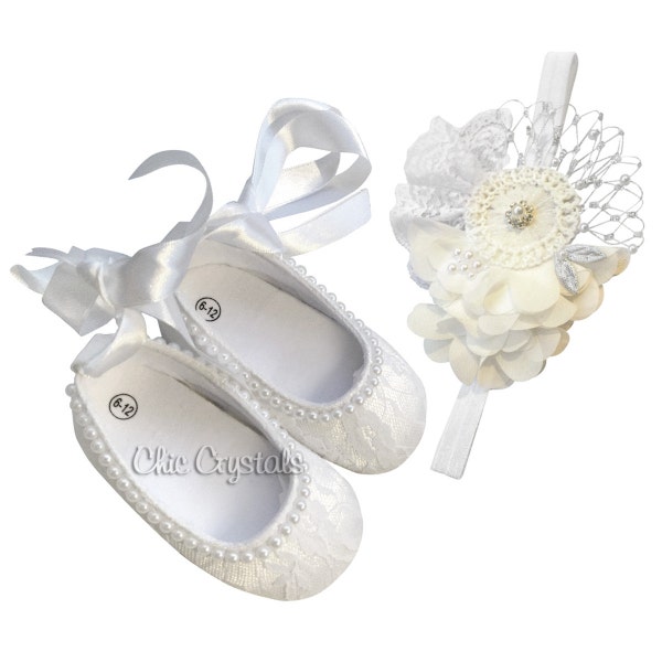Könnte beinhalten: Weiße Babyschuhe mit Spitze und Perlenbesatz, gebunden mit einem Satinband. Ein passendes weißes Stirnband mit einer Blume und silbernem Netzdetail ist enthalten.