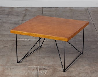 May include: A square wooden coffee table with a black metal frame. The table has a simple, mid-century modern design.