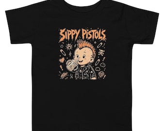 May include: A black short-sleeve t-shirt featuring a graphic of a baby with a mohawk hairstyle wearing a leather jacket and drinking from a bottle. The text "SIPPY PISTOLS" appears above the baby, surrounded by small icons like safety pins, a skull, and stars.