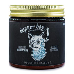 May include: A jar of "dapper boy" water-based pomade. The black label features a stylized dog illustration with tattoos. The jar is 4 ounces (113.4 grams) with a firm hold and medium shine. The lid is gold-colored.