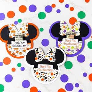 May include: Three mouse-shaped paper cards with bows, each featuring a pocket holding a dollar bill. The cards display the text Thank You Mousekeeping! and are decorated with orange pumpkin, star, and witch hat patterns on white backgrounds.
