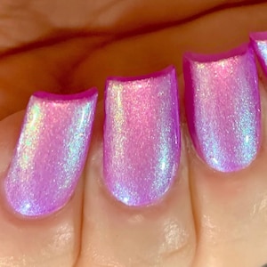 May include: Four fingernails painted with a light purple nail polish with a holographic shimmer.
