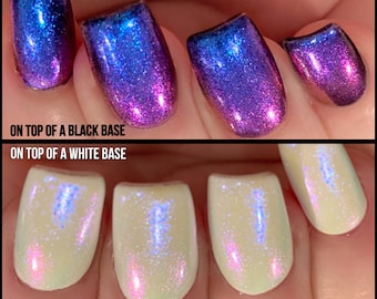 Puede incluir: Primer plano de una mano con cuatro uñas pintadas con un esmalte de uñas holográfico. El esmalte cambia de azul a morado a rosa dependiendo del ángulo de la luz. El pie de foto dice "Encima de una base negra" y "Encima de una base blanca".