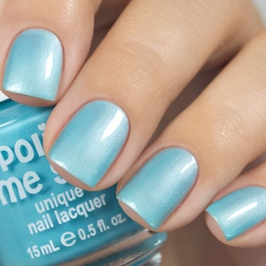 May include: A bottle of light blue nail polish with the brand name "Polished Me" and the text "unique nail lacquer" on the label. The bottle is 15 ml or 0.5 fl. oz.