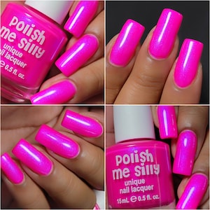May include: Pink nail polish bottle with the text "Polish me silly" and "unique nail lacquer" on the label. The bottle is next to a hand with pink nails painted with a shimmery finish.