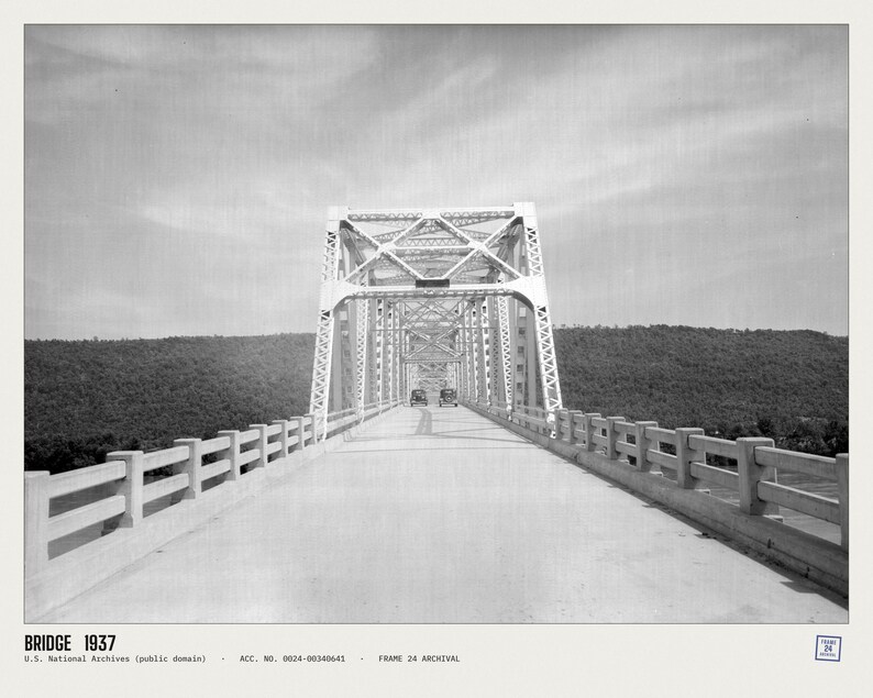 May include: A black and white archival photograph of a steel truss bridge from 1937. The image shows a long, straight road leading into the bridge structure, flanked by concrete railings. Two vintage cars are visible in the distance on the road.