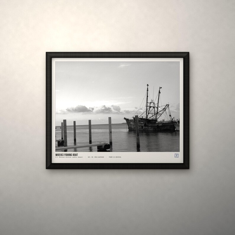 May include: A black and white framed print featuring a fishing boat docked near wooden pilings in calm water. The text at the bottom reads WOE163 FISHING BOAT, U.S. National Archives (Public Domain), ACC. NO. 0863-6405000, PRINT IS ARCHIVAL.