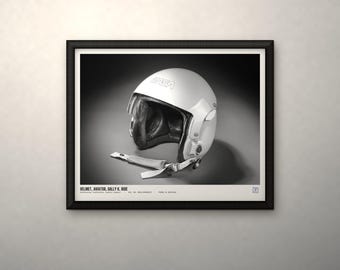 May include: A framed black and white print featuring a white NASA aviator helmet with a dark interior lining and a chin strap. The text below the helmet reads: HELMET, AVIATOR, SALLY K. RIDE. The print is enclosed in a simple black frame.