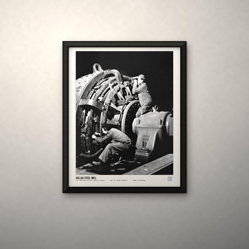 K&ouml;nnte beinhalten: Ein schwarz-wei&szlig; gerahmtes Foto, das zwei Arbeiter bei der Bedienung gro&szlig;er Industriemaschinen im Sollac-Stahlwerk zeigt. Der Druck enth&auml;lt den Text SOLLAC STEEL MILL, U.S. National Archives (public domain) sowie weiteren kleinen Text am unteren Rand.
