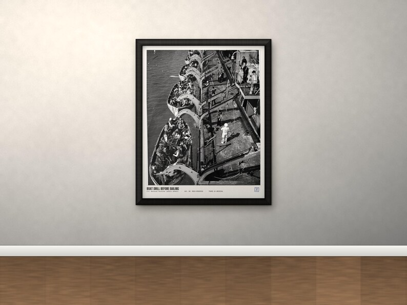 May include: A black and white framed print titled BOAT DRILL BEFORE SAILING, depicting a high-angle view of multiple lifeboats filled with people alongside a large ship deck, with individuals standing on the deck during a maritime safety exercise.