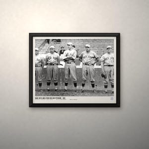 May include: A black and white framed photograph featuring five baseball players in Red Sox uniforms standing on a field. The text below the image reads: BABE RUTH AND OTHER RED SOX PITCHERS 1915. The frame is black with a white mat border.