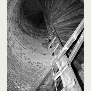 May include: A black and white photograph of a spiral wooden staircase inside a brick lighthouse tower. The image includes the text: HISTORIC LIGHTHOUSE STAIRCASE, U.S. National Archives (public domain), ACC. NO. 0024-66709606, FRAME 24 ARCHIVAL.