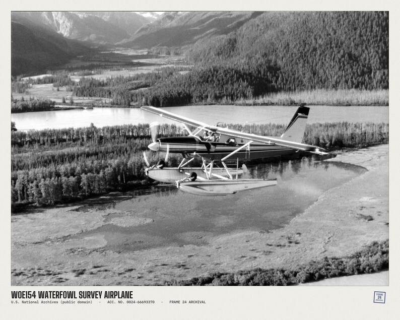 Peut inclure: Une photographie en noir et blanc d'un hydravion survolant une rivi&egrave;re et une for&ecirc;t. Le texte en bas indique WOE154 WATERFOWL SURVEY AIRPLANE, U.S. National Archives (public domain), ACC. NO. 0024-66693378, FRAME 24 ARCHIVAL.