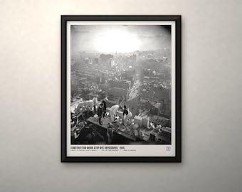 May include: A black and white framed print titled CONSTRUCTION WORK ATOP NYC SKYSCRAPER 1905. The image depicts workers on a high-rise building structure overlooking a city skyline with a bright, hazy sky in the background.